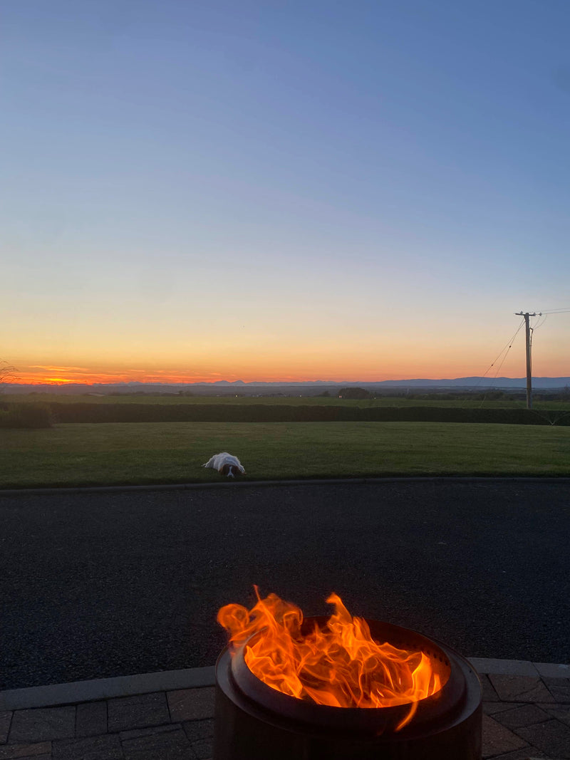 Flame from a fire pit against a blue sky in Longridge.